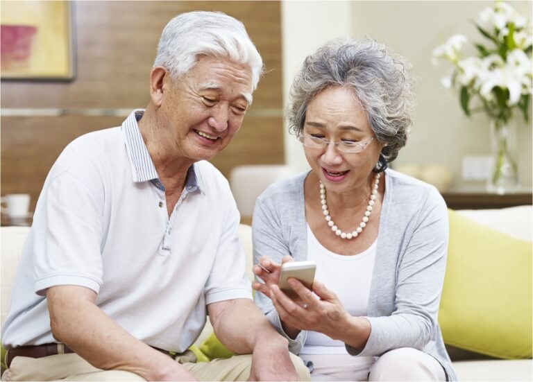 husband and wife look at their mobile phone