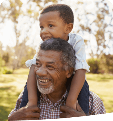 Grandson sitting on grandfather's shoulders
